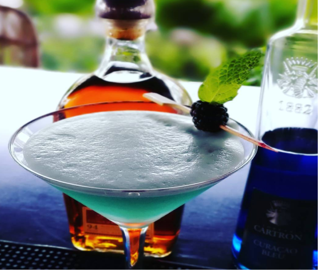 Blue curaçao cocktail with blackberry garnish
